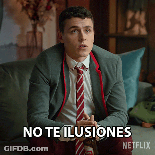 A Man In A Suit And Tie Is Sitting On A Couch With The Words No Te Ilusiones Written On The Screen GIF