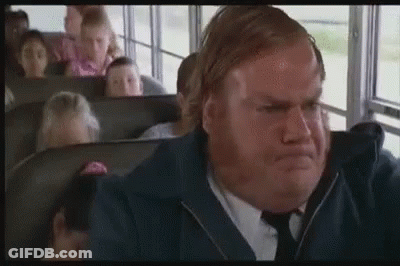 A Man In A Suit And Tie Is Sitting On A School Bus . GIF