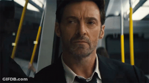 A Man In A Suit And Tie Is Sitting On A Train GIF