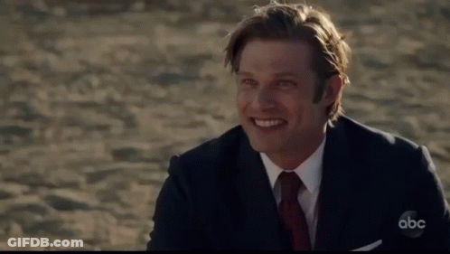 Man In Suit Sitting On Beach With ABC GIF