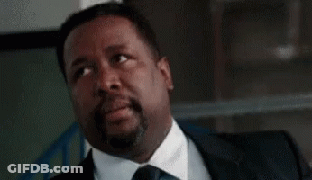 A Man In A Suit And Tie Is Sitting With His Eyes Closed And His Mouth Open . GIF
