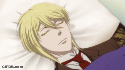 A Man In A Suit And Tie Is Sleeping In A Bed With His Eyes Closed GIF