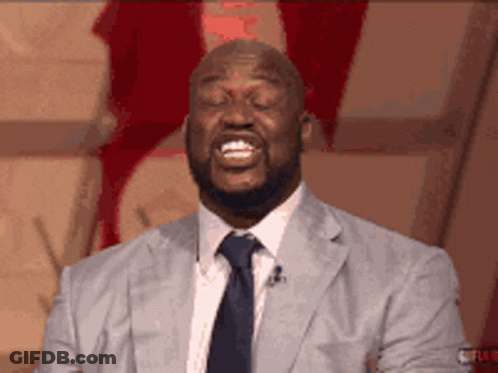 A Man In A Suit And Tie Is Smiling GIF