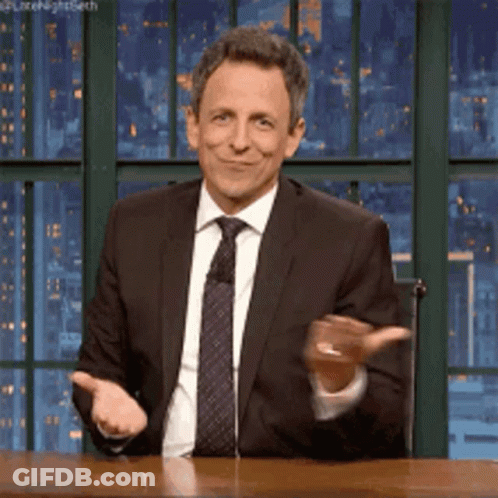 A Man In A Suit And Tie Is Smiling And Clapping GIF