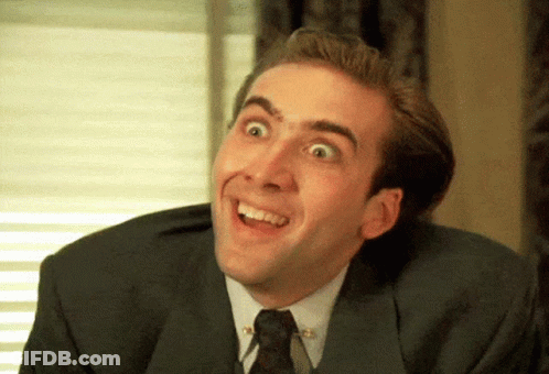A Man In A Suit And Tie Is Smiling And Looking Up GIF