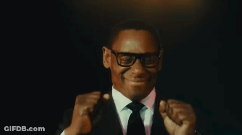 Man In Suit And Tie Smiling And Fist Pumping GIF