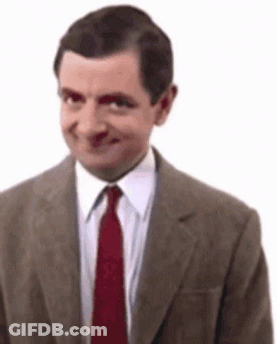 A Man In A Suit And Tie Is Smiling And Making A Funny Face . GIF