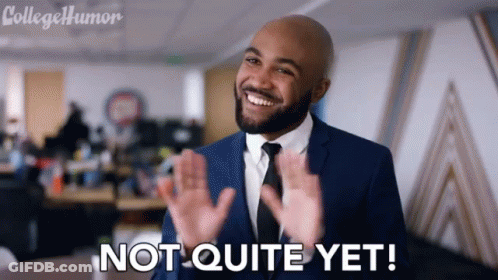 A Man In A Suit And Tie Is Smiling And Says Not Quite Yet GIF