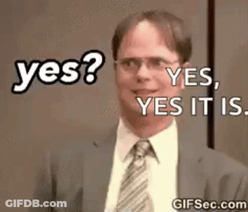 A Man In A Suit And Tie Is Smiling And Says Yes . GIF