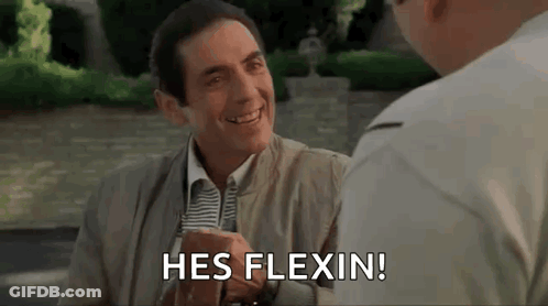 A Man In A Suit And Tie Is Smiling And Talking To Another Man While Sitting At A Table . GIF