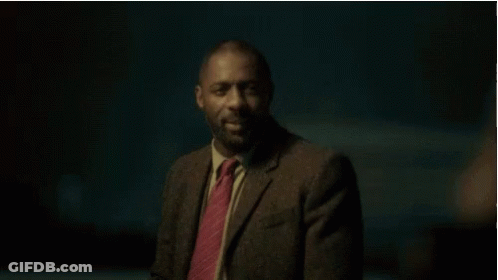 A Man In A Suit And Tie Is Smiling At Someone GIF