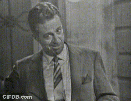 A Man In A Suit And Tie Is Smiling GIF