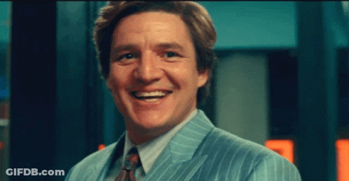 A Man In A Suit And Tie Is Smiling For The Camera GIF