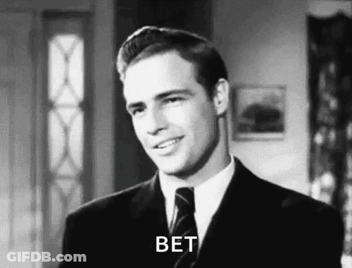 A Man In A Suit And Tie Is Smiling In A Black And White Photo And Says Bet . GIF