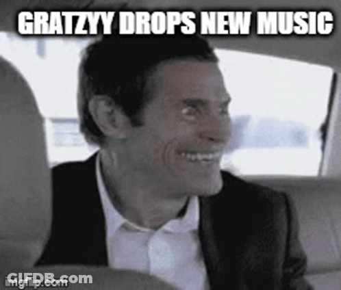 A Man In A Suit And Tie Is Smiling In A Car . GIF