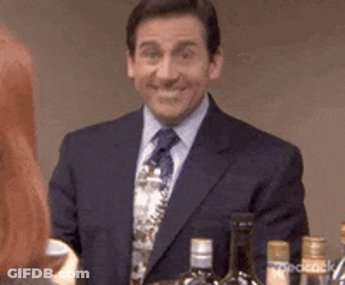 A Man In A Suit And Tie Is Smiling In Front Of A Bar . GIF