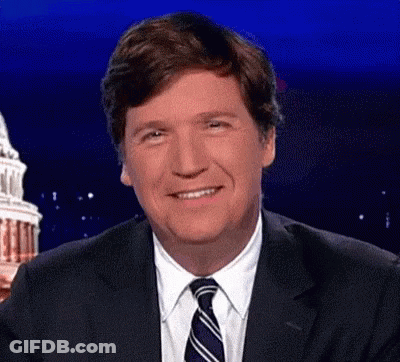 A Man In A Suit And Tie Is Smiling In Front Of A Building . GIF