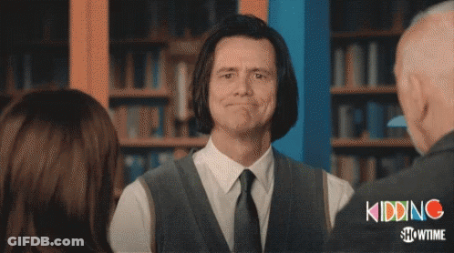A Man In A Suit And Tie Is Smiling In Front Of A Showtime Logo GIF