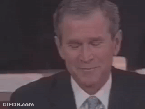 A Man In A Suit And Tie Is Smiling . GIF