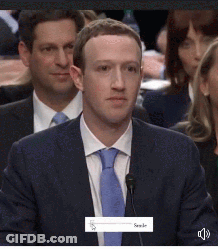 A Man In A Suit And Tie Is Smiling While Sitting At A Microphone GIF