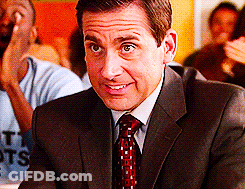 A Man In A Suit And Tie Is Smiling While Sitting At A Table With Other People GIF