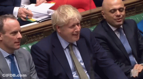 A Man In A Suit And Tie Is Smiling While Sitting Next To Two Other Men In Suits And Ties GIF