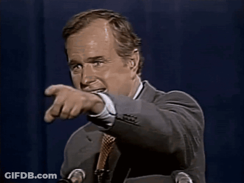 A Man In A Suit And Tie Is Smiling While Speaking Into A Microphone GIF