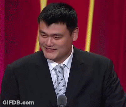 A Man In A Suit And Tie Is Smiling While Speaking Into A Microphone GIF