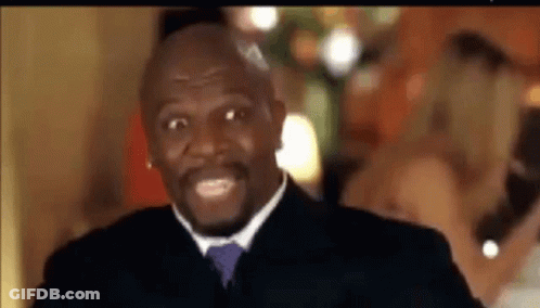A Man In A Suit And Tie Is Smiling While Standing In Front Of A Group Of People . GIF