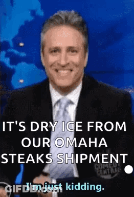 A Man In A Suit And Tie Is Smiling While Talking About Dry Ice From Omaha Steaks Shipment . GIF