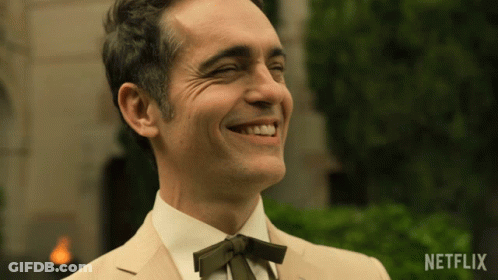 A Man In A Suit And Tie Is Smiling With A Netflix Logo On The Bottom Right GIF