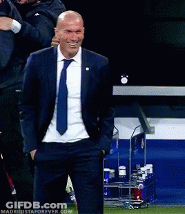 A Man In A Suit And Tie Is Smiling With His Hands In His Pockets .. GIF