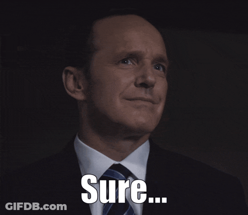 A Man In A Suit And Tie Is Smiling With The Word Sure Below Him GIF
