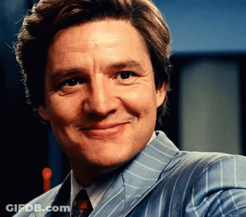 A Man In A Suit And Tie Is Smiling . GIF