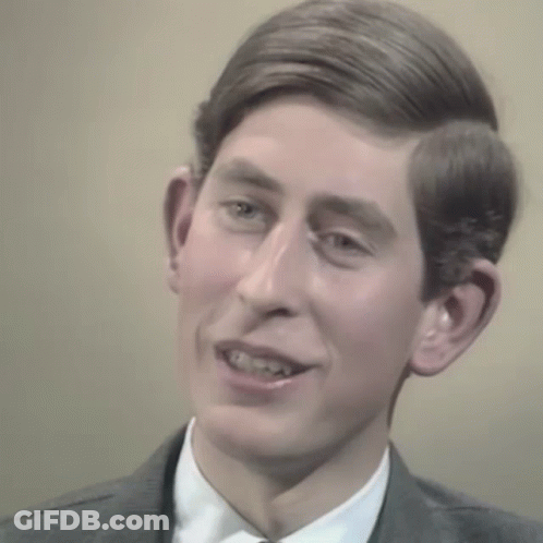 A Man In A Suit And Tie Is Smiling GIF