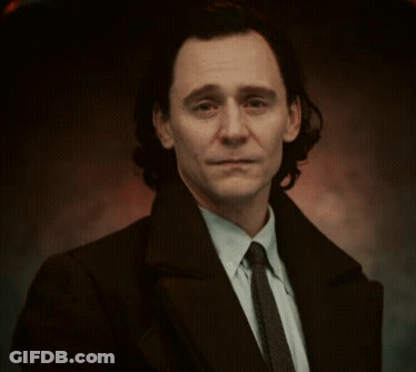 A Man In A Suit And Tie Is Smiling . GIF