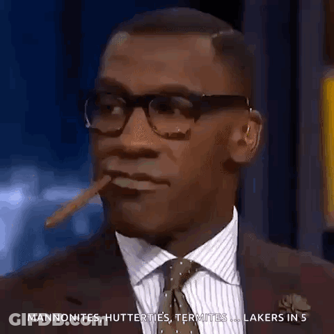 A Man In A Suit And Tie Is Smoking A Cigar And Talking About The Lakers GIF