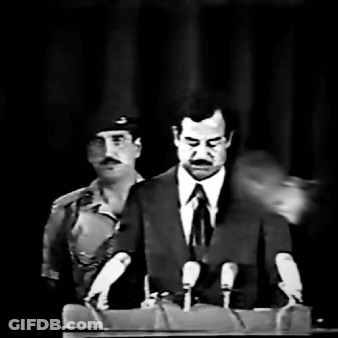 A Man In A Suit And Tie Is Speaking Into Microphones GIF