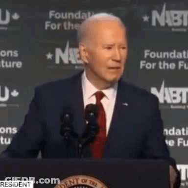 Man In Suit And Tie Giving Speech At Podium GIF
