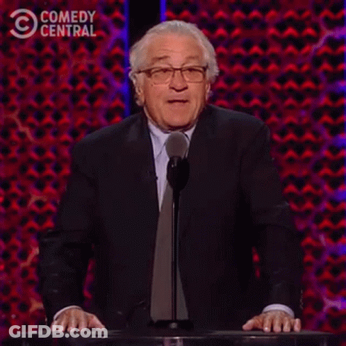 A Man In A Suit And Tie Is Standing At A Podium Giving A Speech And Saying `` Not One '' . GIF