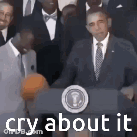 A Man In A Suit And Tie Is Standing At A Podium With The Words `` Cry About It '' Written Below Him . GIF