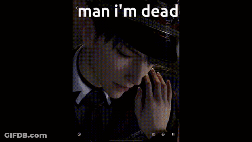 A Man In A Suit And Tie Is Standing In A Dark Room . GIF