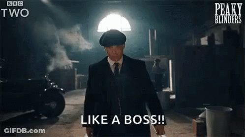A Man In A Suit And Tie Is Standing In A Dark Room Holding A Knife And Says `` Like A Boss '' . GIF