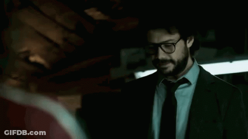 A Man In A Suit And Tie Is Standing In A Dark Room Talking To Another Man . GIF