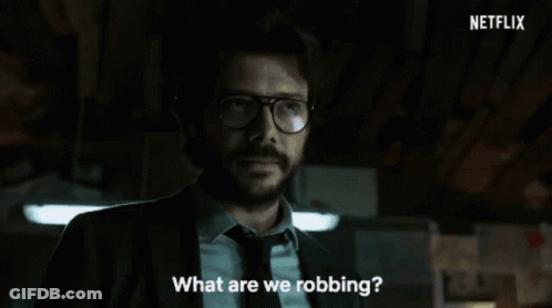 A Man In A Suit And Tie Is Standing In A Dark Room With Netflix Written In The Corner GIF