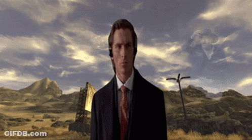 A Man In A Suit And Tie Is Standing In A Desert GIF