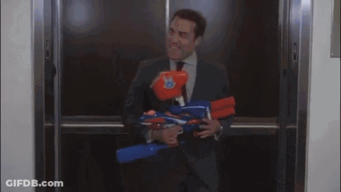 A Man In A Suit And Tie Is Standing In A Hallway Holding A Folder GIF