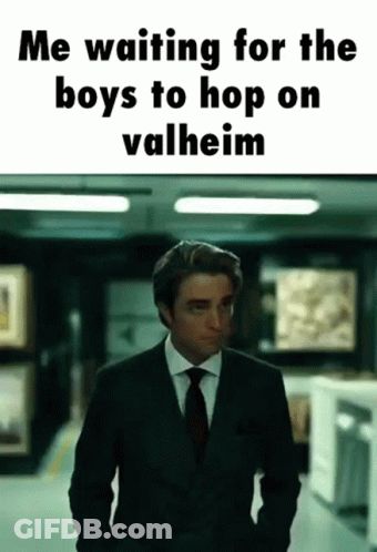 A Man In A Suit And Tie Is Standing In A Hallway With The Caption " Me Waiting For The Boys To Hop On Valheim " GIF