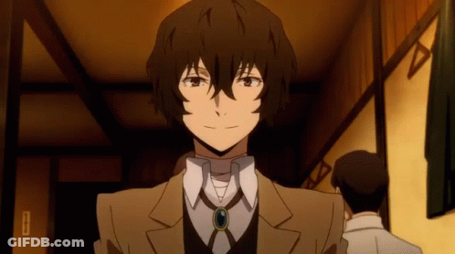 A Man In A Suit And Tie Is Standing In A Room With Other Men . GIF