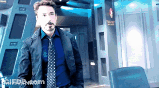 A Man In A Suit And Tie Is Standing In A Room With The Name Gravello2023 In The Corner GIF